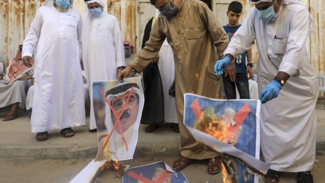 رجال فلسطينيون يحرقون صورا مشطوبة للعاهل البحريني والرئيس الأمريكي ورئيس الوزراء الإسرائيلي خلال مظاهرة في دير البلح، وسط قطاع غزة، 12 سبتمبر 2020 (MAHMUD HAMS / AFP)