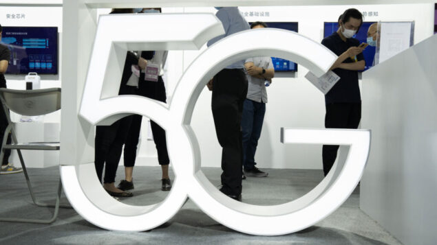 زوار يرتدون أقنعة للحماية من فيروس كورونا يمرون خلف لافتة 5G في معرض بكين الدولي للتكنولوجيا الفائقة في بكين، الصين، 17 سبتمبر 2020 (AP Photo / Ng Han Guan)
