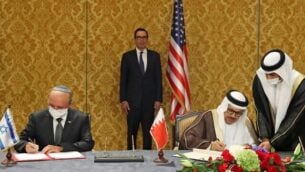 رئيس الوفد الإسرائيلي، مستشار الأمن القومي مئير بن شبات (إلى اليسار)، ووزير الخارجية البحريني عبد اللطيف بن راشد الزياني، يوقعان على اتفاق إسرائيلي بحريني لإضفاء الطابع الرسمي على العلاقات الدبلوماسية، في العاصمة البحرينية المنامة، 18 أكتوبر، 2020. بينهما يقف وزير الخزانة الأمريكي ستيف منوشين. (Ronen Zvulun/Pool/AFP)