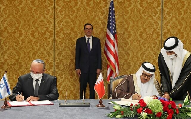 رئيس الوفد الإسرائيلي، مستشار الأمن القومي مئير بن شبات (إلى اليسار)، ووزير الخارجية البحريني عبد اللطيف بن راشد الزياني، يوقعان على اتفاق إسرائيلي بحريني لإضفاء الطابع الرسمي على العلاقات الدبلوماسية، في العاصمة البحرينية المنامة، 18 أكتوبر، 2020. بينهما يقف وزير الخزانة الأمريكي ستيف منوشين. (Ronen Zvulun/Pool/AFP)