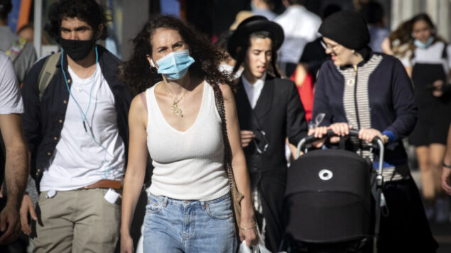 أشخاص يرتدون أقنعة يسيرون في وسط مدينة القدس، خلال إغلاق على مستوى البلاد، 15 أكتوبر 2020 (Olivier Fitoussi / Flash90)
