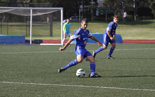 Club president and player, Michael Katz, clears the ball from defence