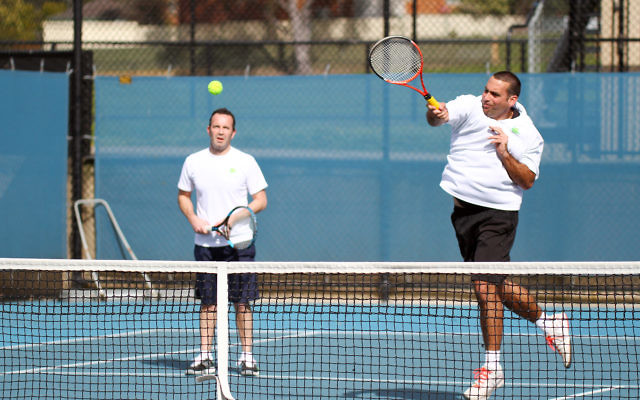 Asaf Nagar smashes a return in the semifinal against Kooyong, while doubles partner Joel Fredman looks on. Photo: Peter Haskin