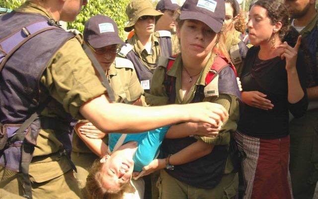 Israeli security personnel evicting a resident of Neve Dekalim.
