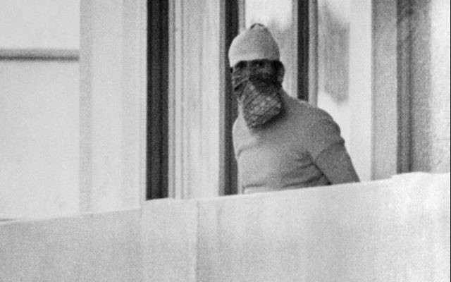 A member of the Palestinian terrorist group Black September appears on the balcony of the Israeli house at the Munich Olympic village on September 5, 1972.