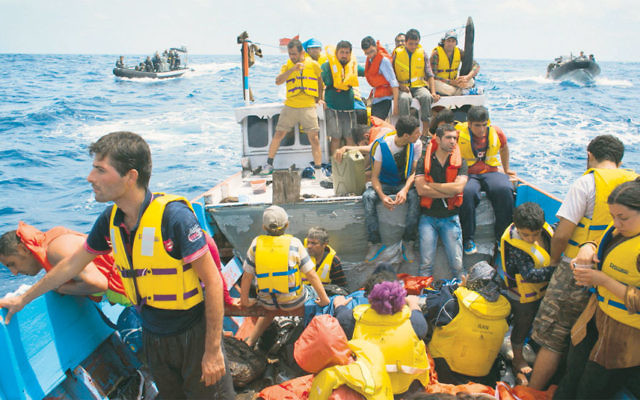 Asylum seekers are escorted by the Australian Navy after being thwarted from reaching Christmas Island.  Photo by New York Times photographer Joel van Houdt