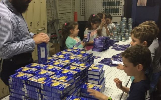 Shlomo Nathanson packing Pesach hampers with C Care “angels”.