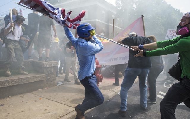 A white supremacist trying to strike a counterprotester with a white nationalist flag during clashes in Charlottesville.
Photo: Samuel Corum/Anadolu Agency/Getty Images/JTA