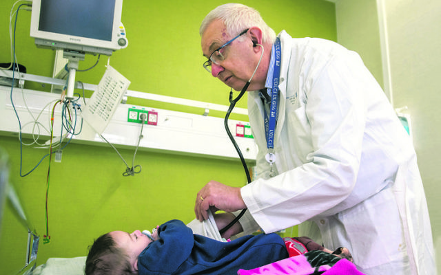 Professor Anthony Luder examines an infant at Ziv Hospital in Israel.