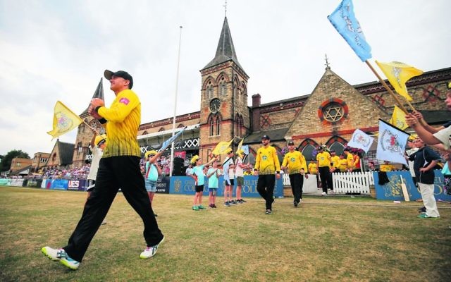 Michael Klinger leads Gloucestershire onto the College Ground at the Cheltenham Cricket Festival in England. A frosted glass window featuring a Magen David can be seen in the background. Photo: Gloucestershire Cricket