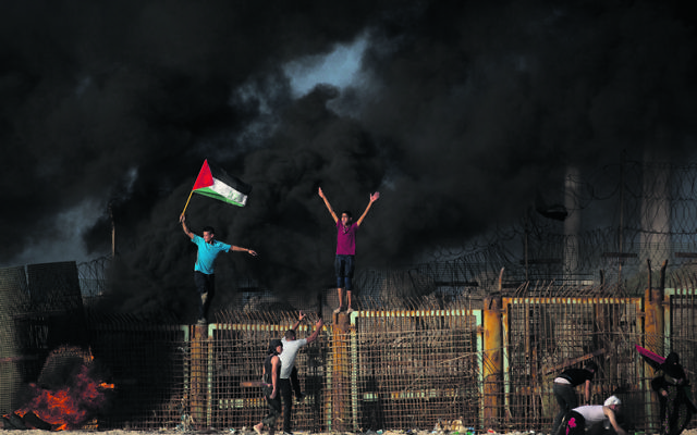 Palestinian protesters climbed over the border fence during a protest on the beach at the border with Israel near Beit Lahiya this week. Photo: AP Photo/Khalil Hamra