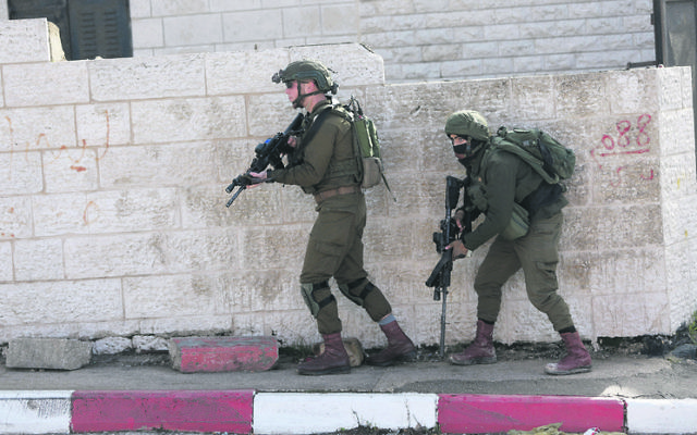 Israeli soldiers conduct a search in Ramallah  for suspects behind the shooting attack. Photo: AP Photo/Majdi Mohammed