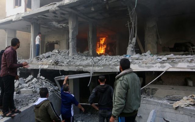 Palestinians walk through the wreckage of a building that was damaged by Israeli airstrikes in Rafah, in the southern Gaza Strip, May 5, 2019. (Abed Rahim Khatib/Flash90)