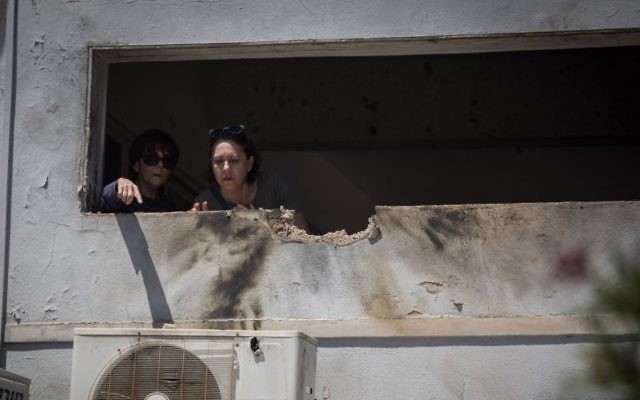 Residents of southern Israel survey the damage to their home by a rocket fired from Gaza on May 4, 2019. (Hadas Parush/Flash90)