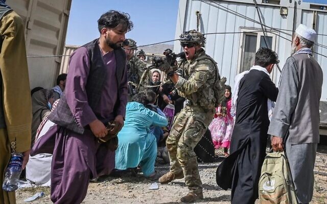 US Soldier points his gun toward an Afghan passenger