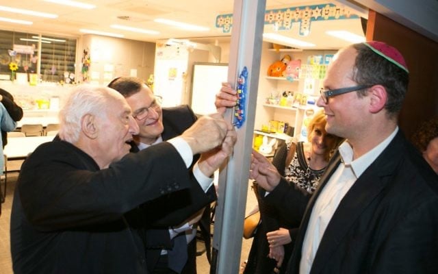 From left: Aron Kleinlehrer, Shmuel Ben-Shmuel, Tracey Waxman and Adam Carpenter, head of Jewish life (primary), affix a mezuzah made by students to the doorpost of a new classroom. Photo: Ofer Levy From left: Aron Kleinlehrer, Shmuel Ben-Shmuel, Tracey Waxman and Adam Carpenter, head of Jewish life (primary), affix a mezuzah made by students to the doorpost of a new classroom. Photo: Ofer Levy