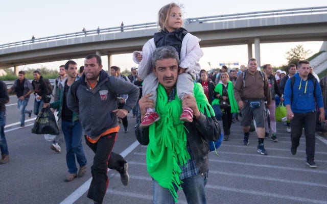 Refugees walking along a motorway near the southern Hungarian village of Roszke last week.
Photo: Matt Cardy/Getty Images Refugees walking along a motorway near the southern Hungarian village of Roszke last week.
Photo: Matt Cardy/Getty Images
