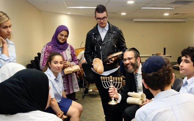 Rabbi Zalman Kastel explains Chanukah to a group of students as teachers Grace Smith, Zohra Aly and Jaxon Jennings look on.
Photo: Noel Kessel Rabbi Zalman Kastel explains Chanukah to a group of students as teachers Grace Smith, Zohra Aly and Jaxon Jennings look on.
Photo: Noel Kessel
