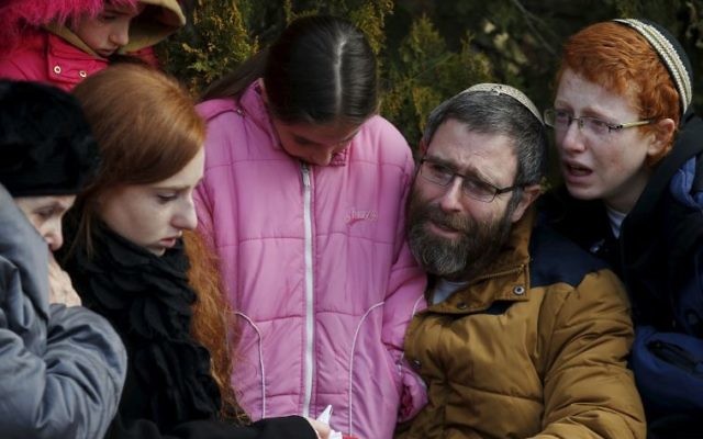 The husband and children of Dafna Meir mourn during her funeral ceremony in Otniel. The husband and children of Dafna Meir mourn during her funeral ceremony in Otniel.