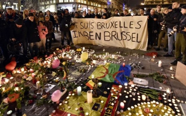 People holding a banner reading "I am Brussels" behind flowers and candles to mourn for the victims at Place de la Bourse in the centre of Brussels. People holding a banner reading "I am Brussels" behind flowers and candles to mourn for the victims at Place de la Bourse in the centre of Brussels.