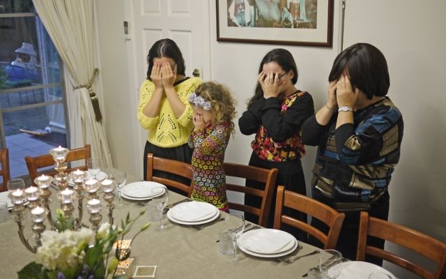 Rebbetzin Laya Slavin prays on a Friday evening with her daughters. Photo: D-Mo Zajac. Rebbetzin Laya Slavin prays on a Friday evening with her daughters. Photo: D-Mo Zajac.