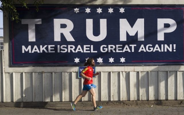 An Israeli jogger passes a pro-Trump placard in Tel Aviv. Photo: EPA/Jim Hollander