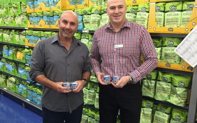 Danny Hochberg (left) and Woolworths Double Bay manager Matthew Walsh with memorial candles that will be in the Zachor Project reading kits.