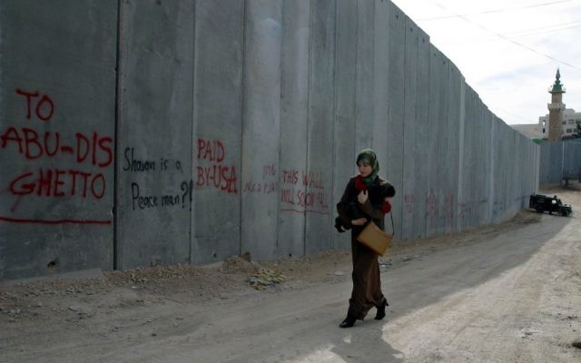 A Palestinian woman carries her child past the security barrier near the village of Abu Dis.
Photo: Brian Hendler/JTA A Palestinian woman carries her child past the security barrier near the village of Abu Dis.
Photo: Brian Hendler/JTA