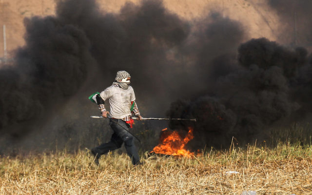 A Palestinian protester burning tyres during clashes with Israeli forces near the Gaza border. Photo: Said Khatib/AFP/Getty Images A Palestinian protester burning tyres during clashes with Israeli forces near the Gaza border. Photo: Said Khatib/AFP/Getty Images