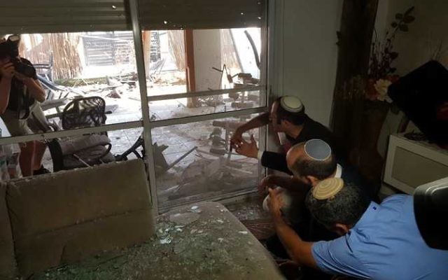Sderot residents survey the damage to a house caused by a rocket from Gaza. Photo: Sderot Municipality Sderot residents survey the damage to a house caused by a rocket from Gaza. Photo: Sderot Municipality