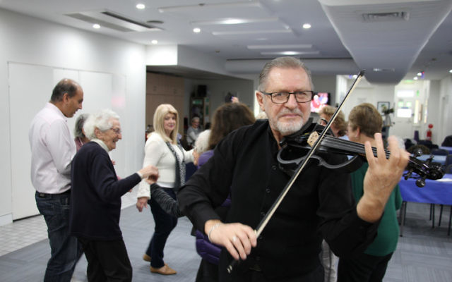 Nik Djumin playing klezmer tunes for COA Sydney clients and staff. 
Photo: Shane Desiatnik