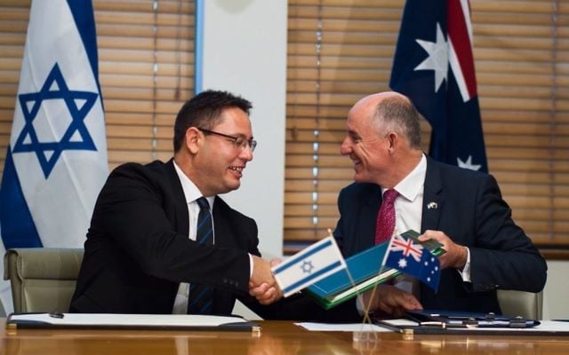 Israeli deputy chief of mission Ron Gerstenfeld (left) and Australian assistant
treasurer Stuart Robert sign the deal. Photo: Twitter Israeli deputy chief of mission Ron Gerstenfeld (left) and Australian assistant
treasurer Stuart Robert sign the deal. Photo: Twitter