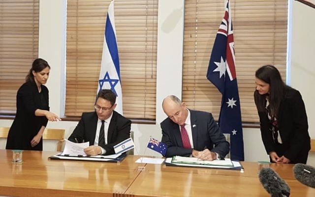 Israeli deputy chief of mission Ron Gerstenfeld (left) and Australian assistant
treasurer Stuart Robert sign the deal. Photo: Twitter Israeli deputy chief of mission Ron Gerstenfeld (left) and Australian assistant
treasurer Stuart Robert sign the deal. Photo: Twitter