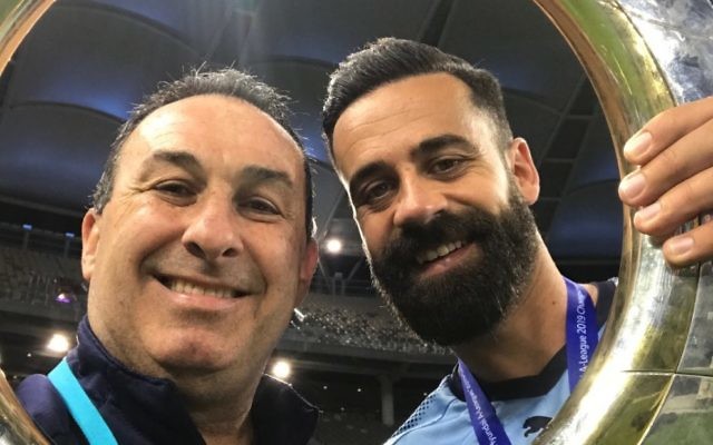 Michael Swibel (left) and retiring
Sydney FC captain Alex Brosque
hold the 2018/19 A-League trophy at
Optus Stadium in Perth last Sunday. Michael Swibel (left) and retiring
Sydney FC captain Alex Brosque
hold the 2018/19 A-League trophy at
Optus Stadium in Perth last Sunday.