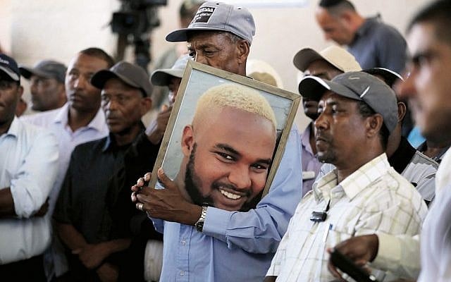 Family members and friends hold a picture of Solomon Teka during his funeral. Photo: EPA/Abir Sultan Family members and friends hold a picture of Solomon Teka during his funeral. Photo: EPA/Abir Sultan