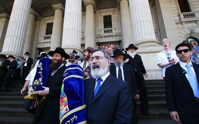 Following a double Torah dedication at Parliament House, Victoria, in 2012, then chief
rabbi Lord Jonathan Sacks carries one of the Torahs in a procession to East Melbourne
Hebrew Congregation. Photo: Peter Haskin Following a double Torah dedication at Parliament House, Victoria, in 2012, then chief
rabbi Lord Jonathan Sacks carries one of the Torahs in a procession to East Melbourne
Hebrew Congregation. Photo: Peter Haskin