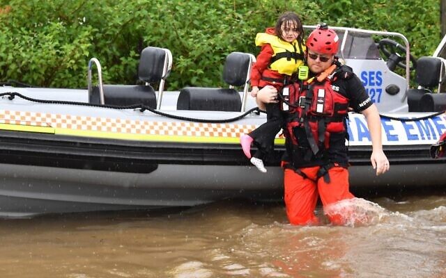 SES assisting a family during their evacuation from a flooded property at
Upper Colo in north-western Sydney this week. Photo: AAP Image/Dean Lewins SES assisting a family during their evacuation from a flooded property at
Upper Colo in north-western Sydney this week. Photo: AAP Image/Dean Lewins