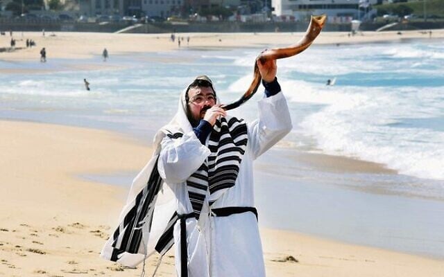 Rabbi Eli Schlanger blows a shofar on Bondi Beach in pre-pandemic days. Rabbi Eli Schlanger blows a shofar on Bondi Beach in pre-pandemic days.