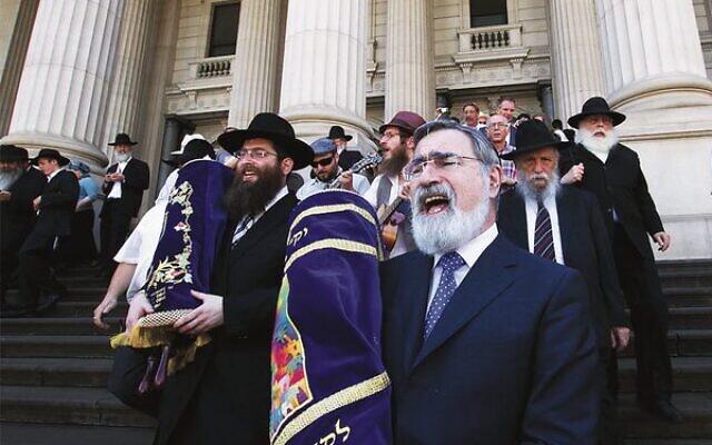 Rabbi Jonathan Sacks and Rabbi Dovid Gutnick (left) lead a procession from Parliament to East Melbourne Shule, following a double Torah dedication in 2012. Photo: Peter Haskin Rabbi Jonathan Sacks and Rabbi Dovid Gutnick (left) lead a procession from Parliament to East Melbourne Shule, following a double Torah dedication in 2012. Photo: Peter Haskin