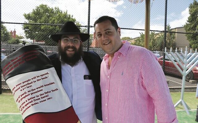 Mendel Schachter and Avi Tatarka with the Torah scroll. Mendel Schachter and Avi Tatarka with the Torah scroll.