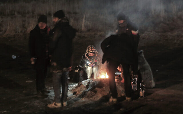 Students gather around a campfire to warm themselves at the Medyka border crossing after fleeing from Ukraine. Photo: AP Photo/Visar Kryeziu Students gather around a campfire to warm themselves at the Medyka border crossing after fleeing from Ukraine. Photo: AP Photo/Visar Kryeziu
