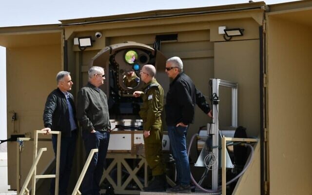Defense Minister Benny Gantz (second from left) is shown a new laser-based air-defense system at a Rafael weapons manufacturer complex in Israel, March 17, 2022. (Defense Ministry) Defense Minister Benny Gantz (second from left) is shown a new laser-based air-defense system at a Rafael weapons manufacturer complex in Israel, March 17, 2022. (Defense Ministry)