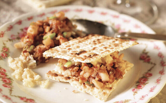 Charoset, shown sandwiched between matzah and on the back left of plate.
Credit: The Hadassah Jewish Holiday Cookbook Charoset, shown sandwiched between matzah and on the back left of plate.
Credit: The Hadassah Jewish Holiday Cookbook