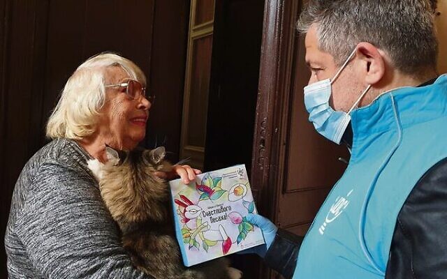 Svetlana Niselevitch receives a haggadah for Passover from a JDC staff member outside her home in Odesa, Ukraine. Photo: JDC via JTA Svetlana Niselevitch receives a haggadah for Passover from a JDC staff member outside her home in Odesa, Ukraine. Photo: JDC via JTA