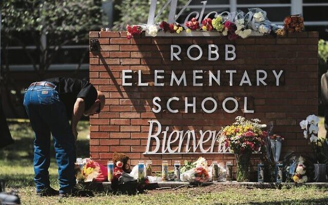 A law enforcement officer lights a candle outside Robb Elementary School in Uvalde, Texas, last week.
Photo: AP/Jae C. Hong A law enforcement officer lights a candle outside Robb Elementary School in Uvalde, Texas, last week.
Photo: AP/Jae C. Hong
