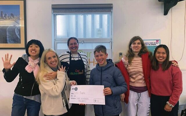 JCA's Lauren Finn (second from left) accepts Liel Rapke's bar mitzvah donation during his time volunteering at Our Kitchen Hand. JCA's Lauren Finn (second from left) accepts Liel Rapke's bar mitzvah donation during his time volunteering at Our Kitchen Hand.