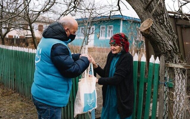 A JDC client in Ukraine receiving her weekly food and medication package. A JDC client in Ukraine receiving her weekly food and medication package.