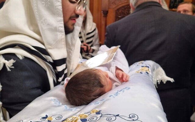 Rabbi Yisrael Blassberger holding the baby about to be named Aharon Chaim. Rabbi Yisrael Blassberger holding the baby about to be named Aharon Chaim.