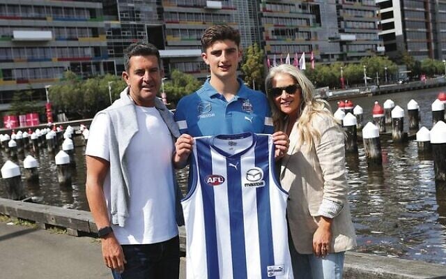 Harry Sheezel (centre) with his dad Dean and mum Lana on November 29. Photo: Peter Haskin