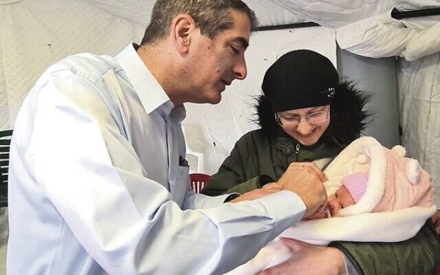 Professor Yitshak Kreiss with a baby at Israel's field hospital in Ukraine. Professor Yitshak Kreiss with a baby at Israel's field hospital in Ukraine.